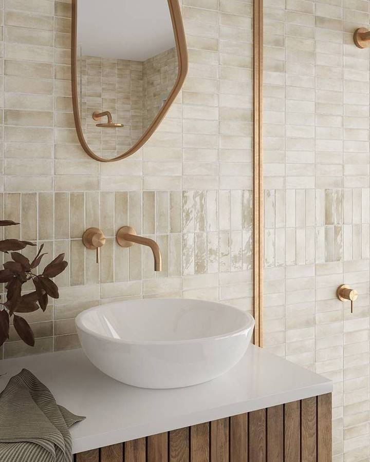 A modern bathroom with cream-colored handmade-look subway tile wall.