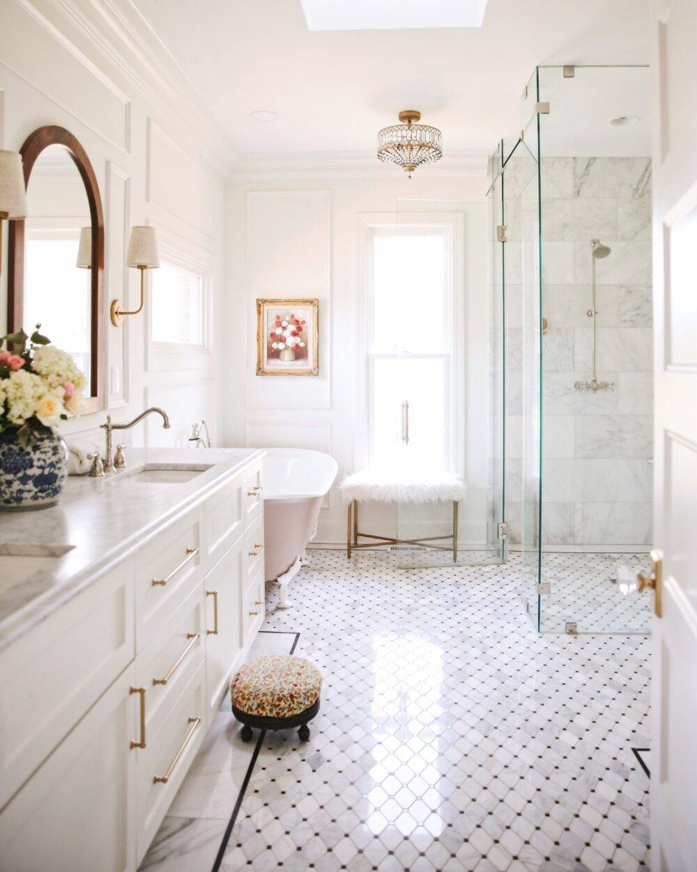 Elegant white marble and black and white marble mosaic tile complete this luxurious bathroom. 