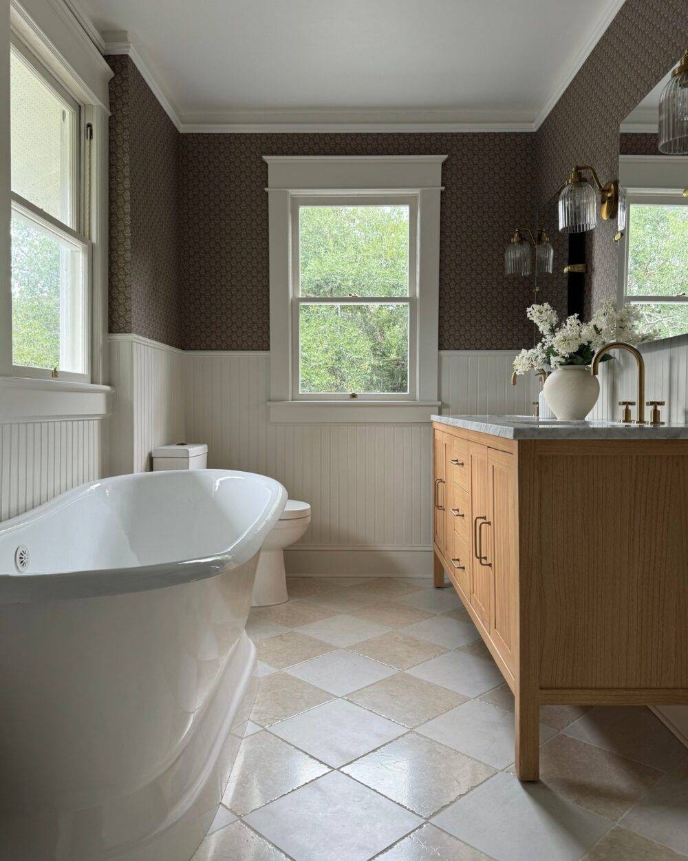 This elegant bathroom features a beige and white marble tile checkerboard floor.