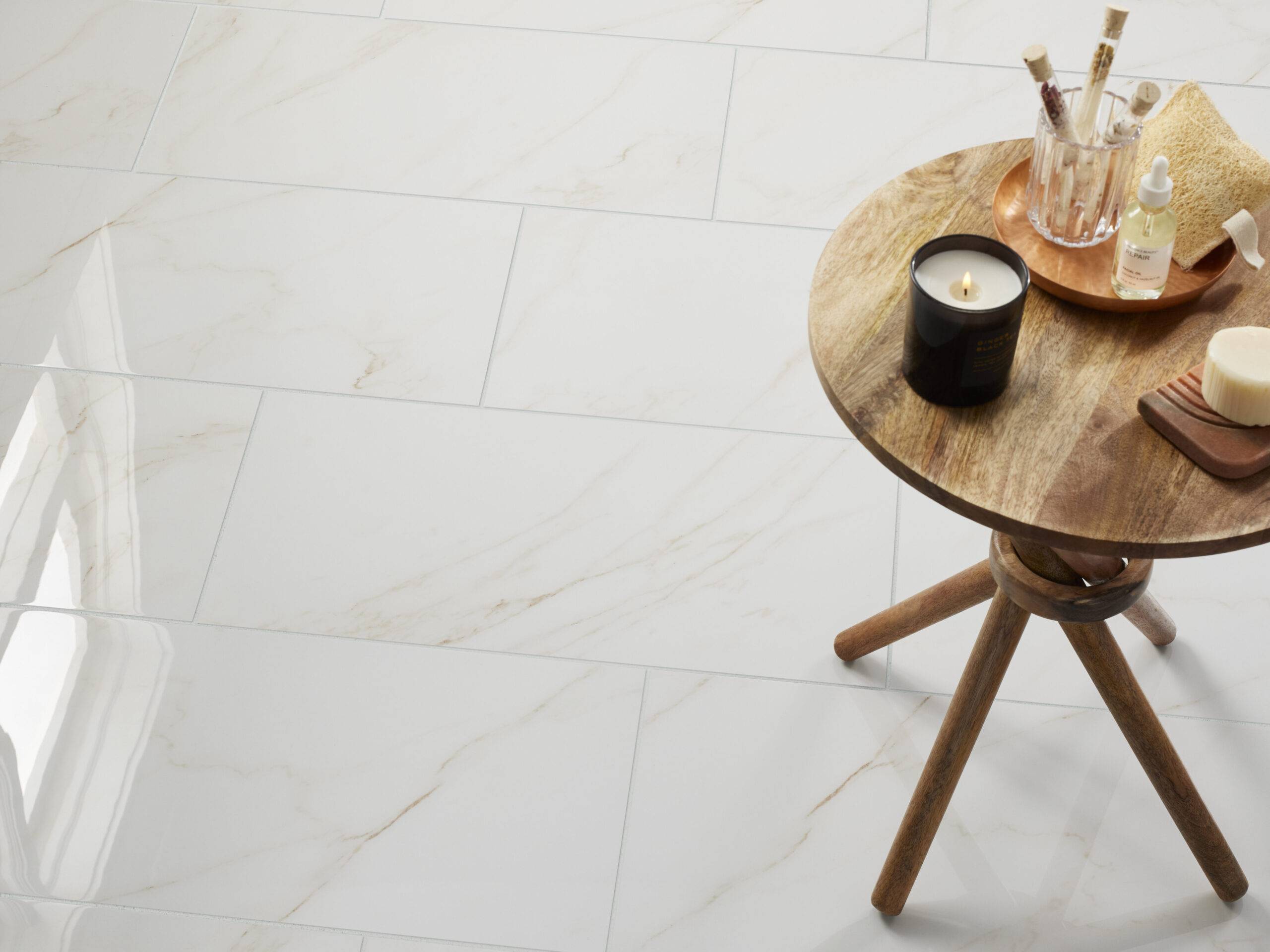 An overhead floor shot of white marble-look tile with soft beige veining. 