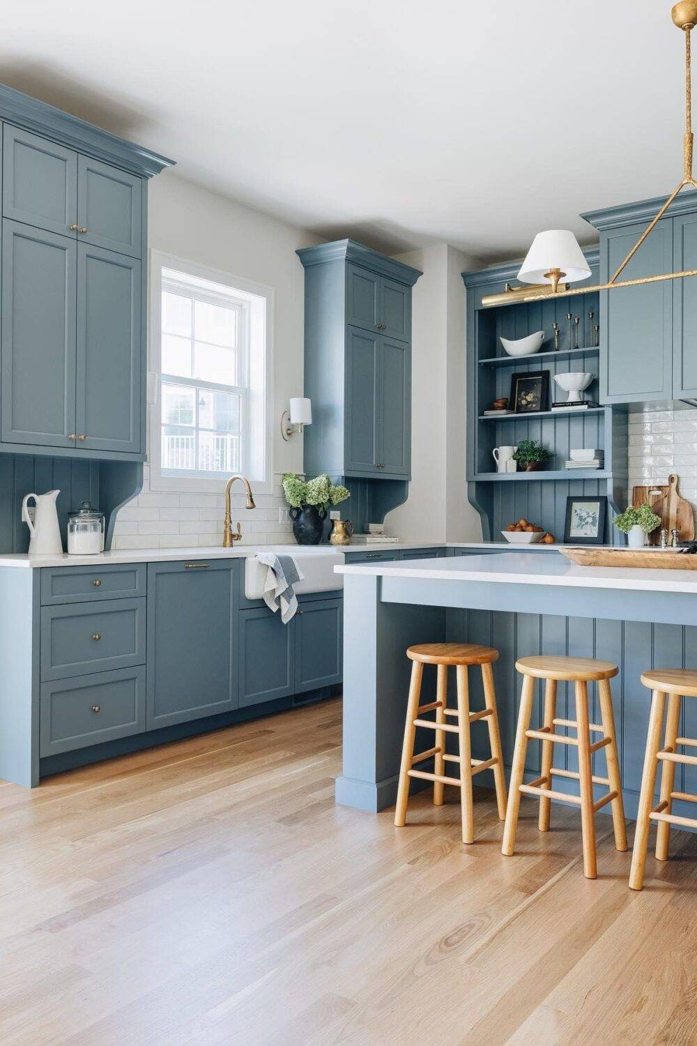 This bright and open kitchen features a white subway tile backsplash and blue cabinets. 