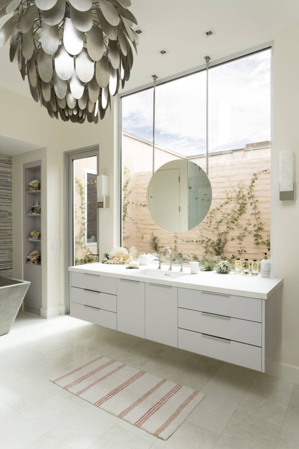 This gorgeous white bathroom features a brushed marble tile floor.