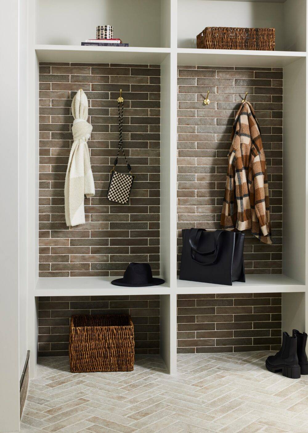 A transitional mudroom featuring brown and beige handmade-look subway tile. 