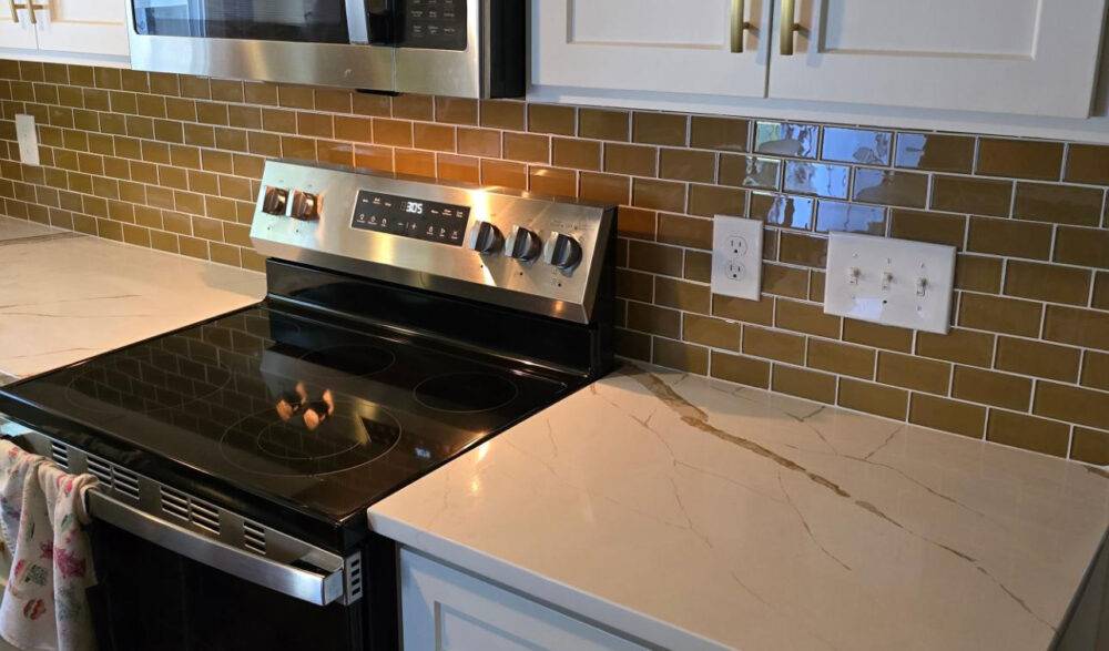 This stylish kitchen features a soft brown subway tile backsplash. 