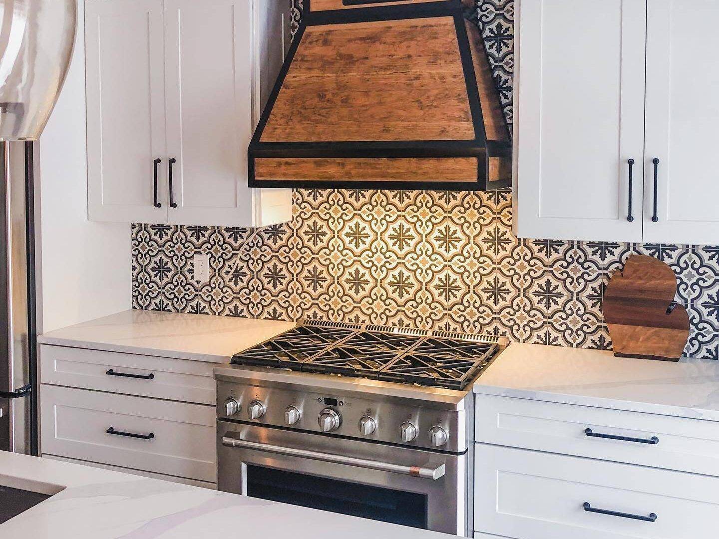 This stylish kitchen features a black, brown and white patterned encaustic tile backsplash. 