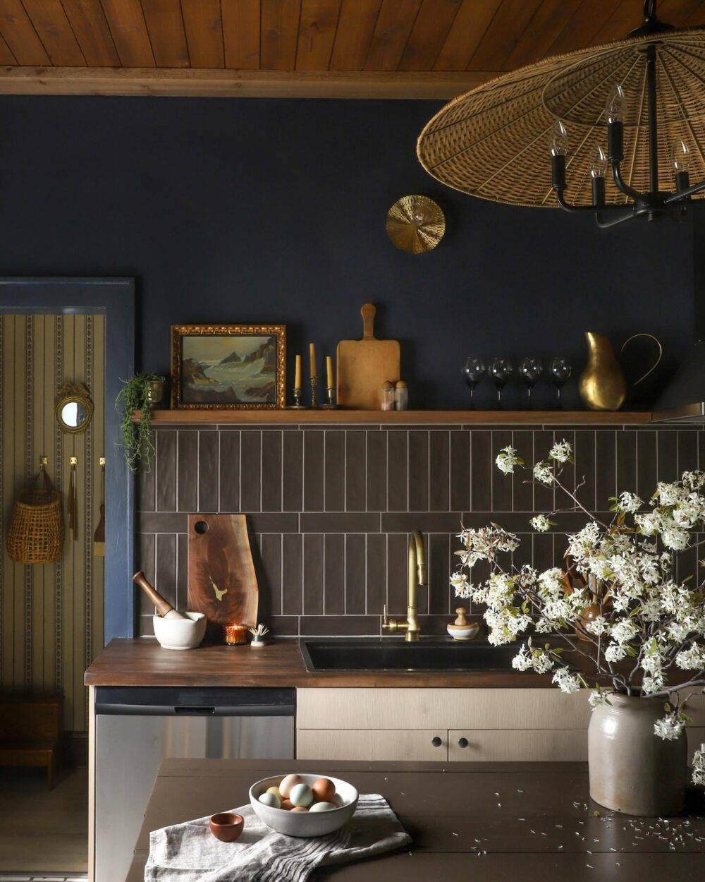 This boho chic kitchen features a dark brown subway tile backsplash in a mix of vertical and horizontal stack. 