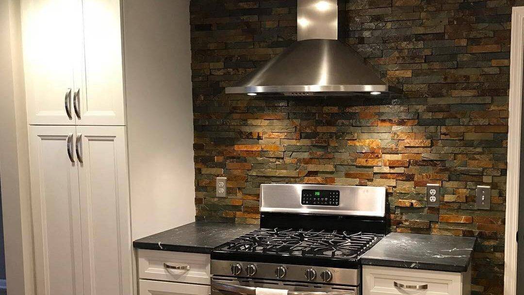 This rustic kitchen features an architectural slate tile backsplash. 