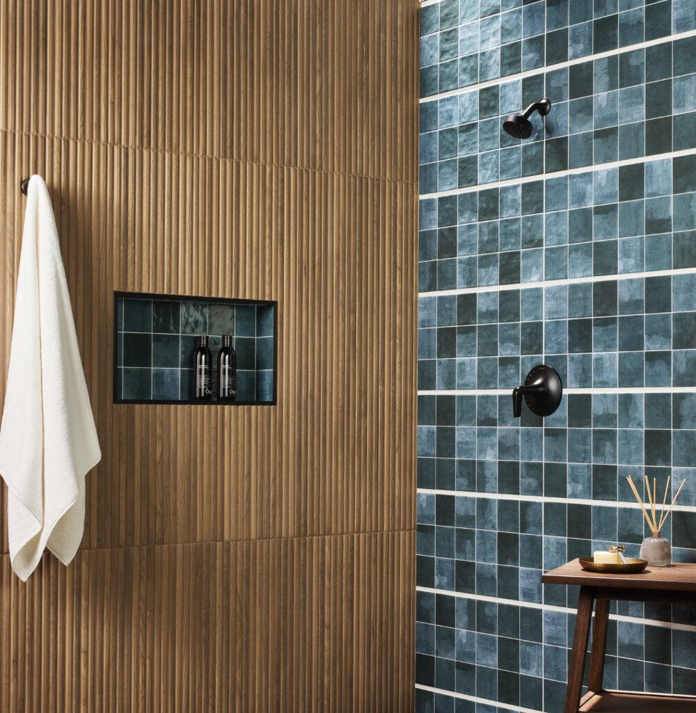 This luxurious shower features a blue handmade-look tile and a fluted wood-look tile accent wall. 