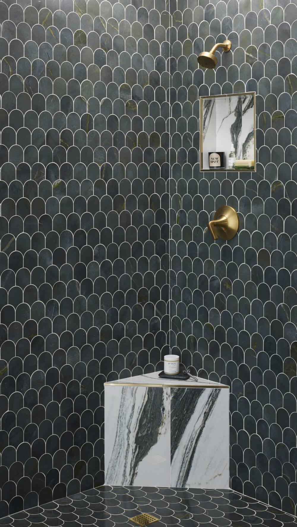 This chic shower features scalloped green marble tile and a marble-look tile with dramatic green veining and gold trim. 