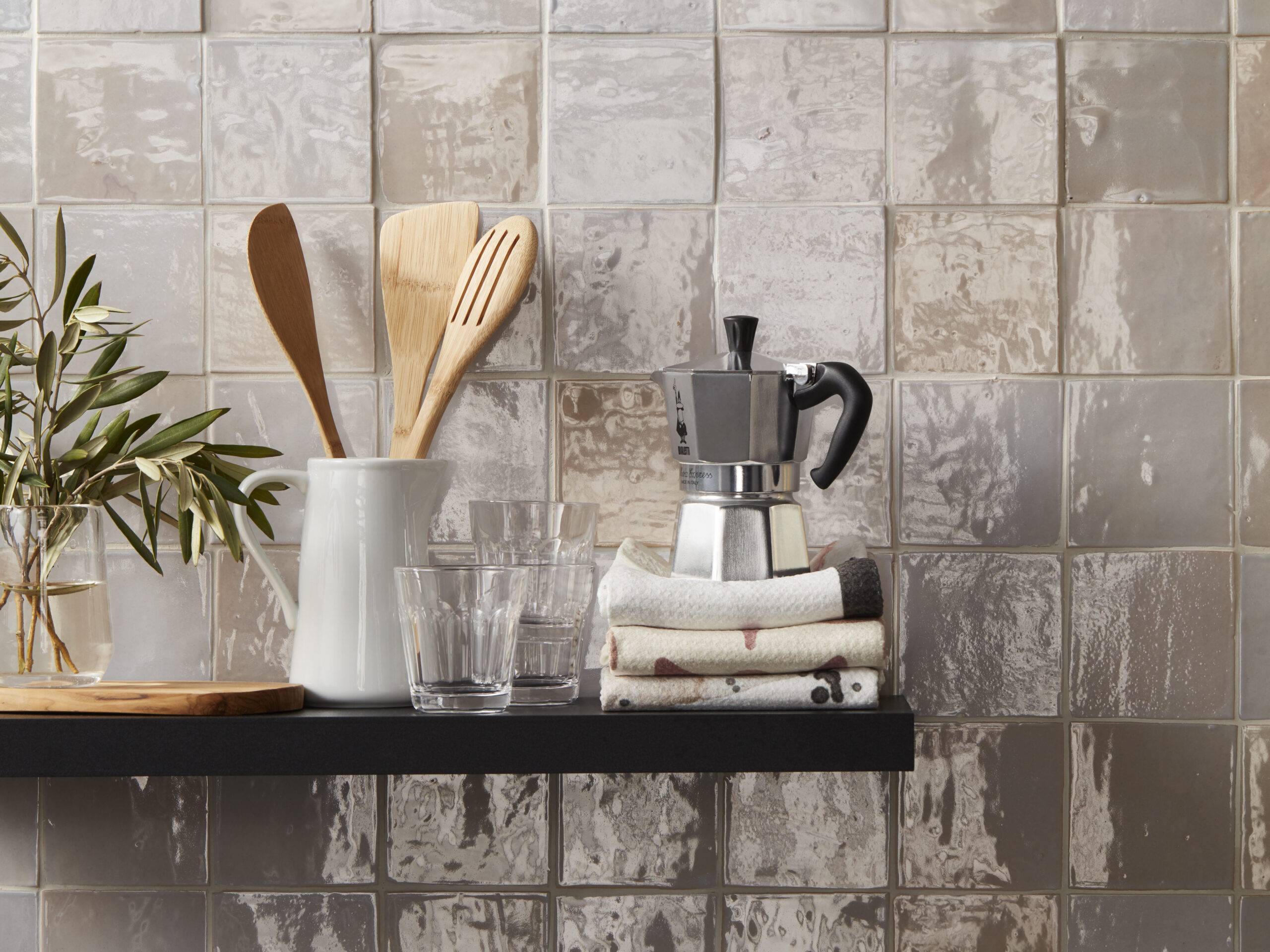 This kitchen wall is covered in glossy beige ceramic handmade Moroccan tile. Each of the square tiles has subtle variation in color and texture, which adds depth to an otherwise simple tiled surface.